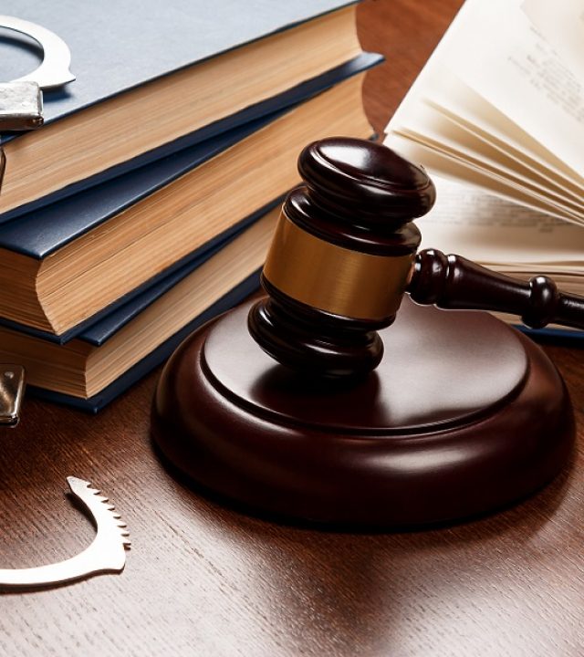 Gavel, books and handcuffs Gavel, books and handcuffs on wooden table